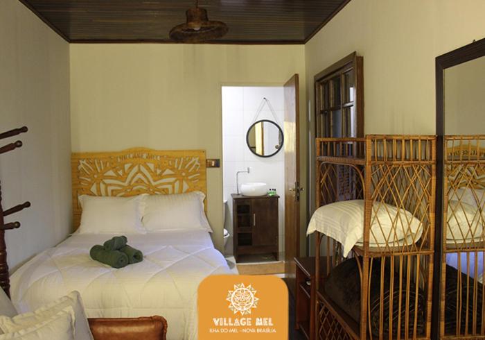 a bedroom with a bed and a bird cage at Pousada Village Mel in Ilha do Mel