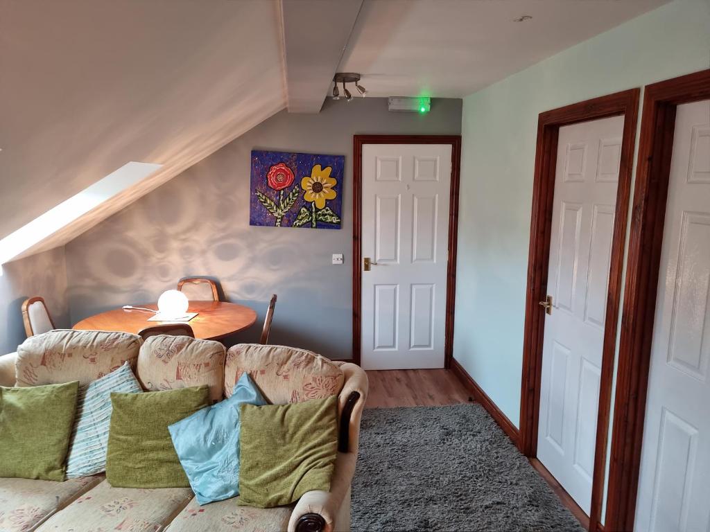 a living room with a couch and a table at Cute loft apartment sleeps 4 in Antrim