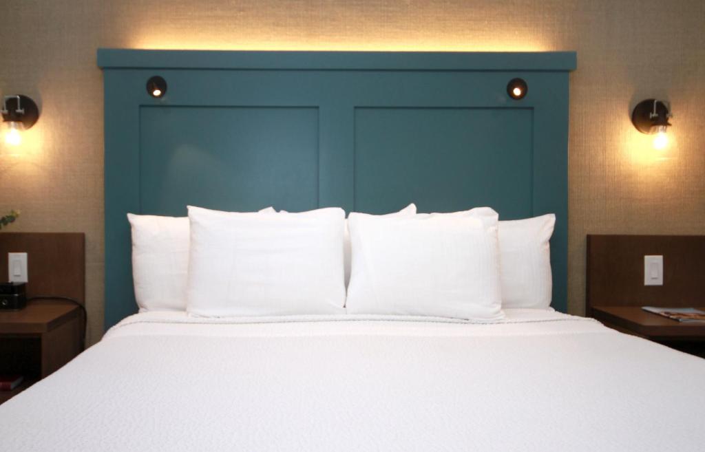 a large bed with a blue headboard and white pillows at Castle Inn in Cambria