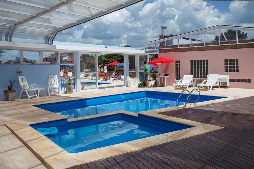 una piscina con patio y una casa en el Apart Hotel Torre Del Sol de Villa Gesell