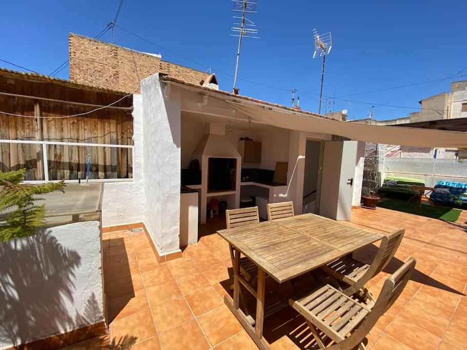 a patio with a wooden table and chairs on a house at Castle view in Alicante