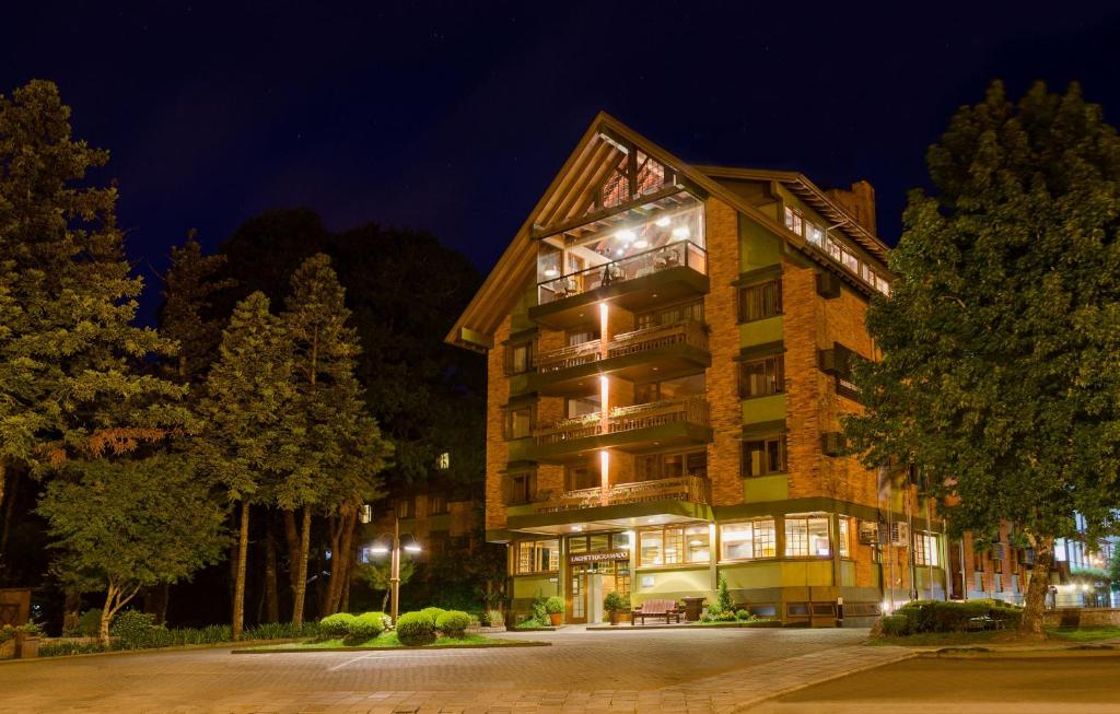 um hotel à noite com árvores em frente em Hotel Laghetto Gramado em Gramado