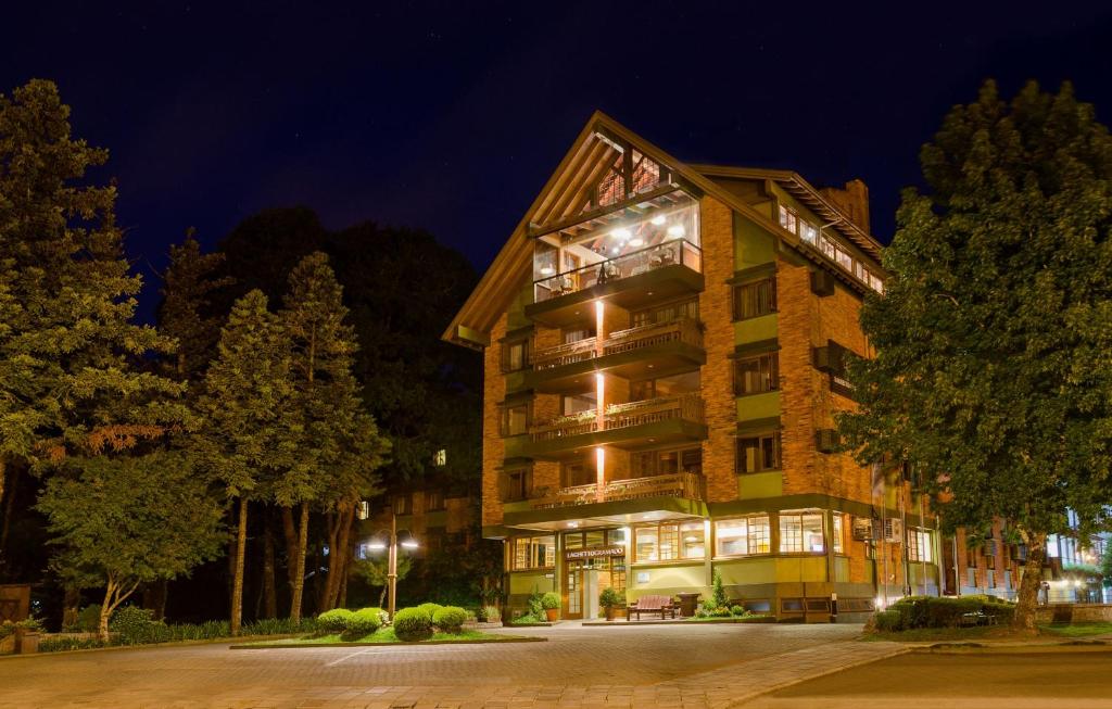 a hotel at night with trees in front of it at Hotel Laghetto Gramado in Gramado