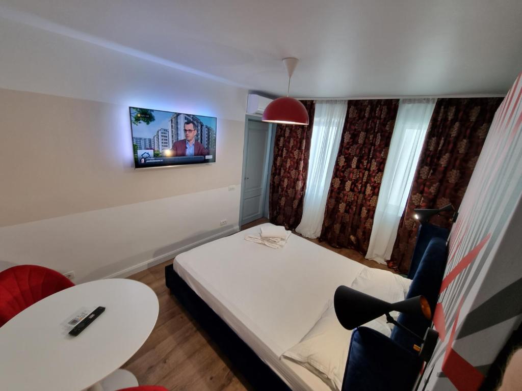 Cette petite chambre comprend un lit et une télévision murale. dans l'établissement Ideal Accommodation City Center, à Bucarest