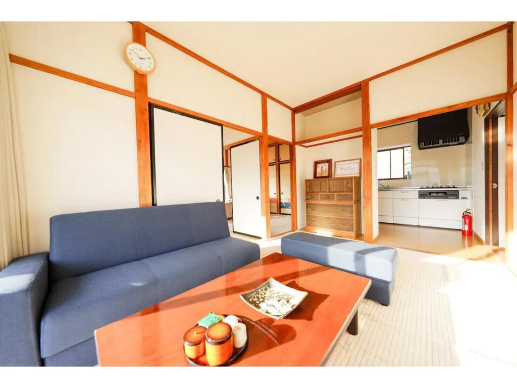 a living room with a blue couch and a table at Second House Nikko - Vacation STAY 13408 in Nikko