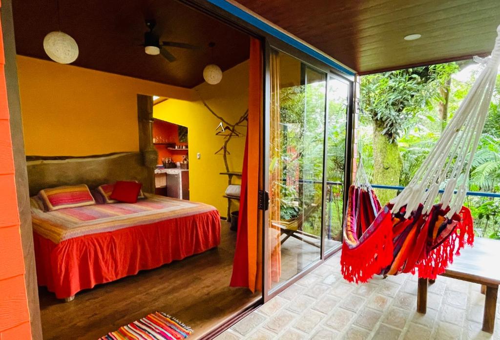 a bedroom with a bed and a hammock in a room at El Sol Monteverde in Monteverde Costa Rica