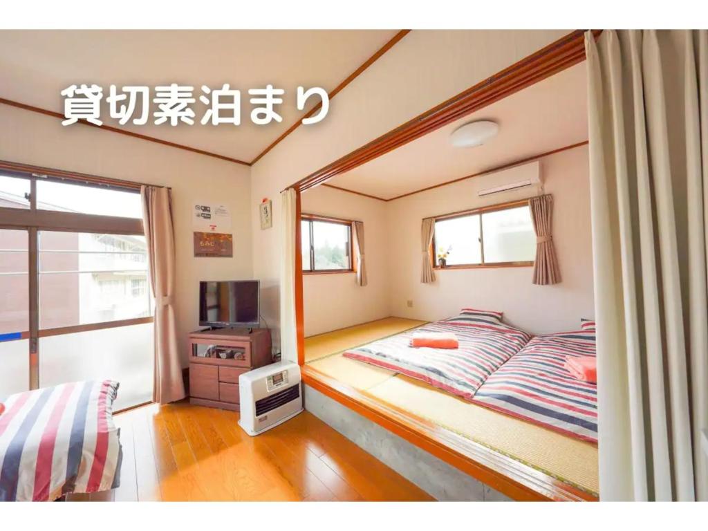 1 dormitorio con 1 cama y TV. en Guest House Momiji Nikko - Vacation STAY 13409 en Nikko