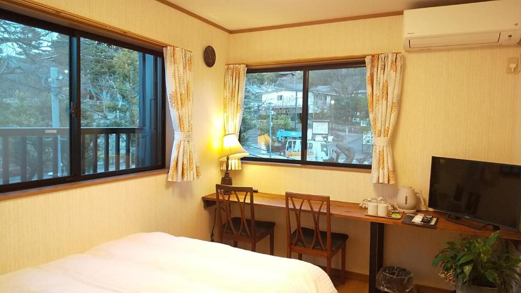 um quarto com uma secretária e uma cama e uma secretária com cadeiras em Guest House Nishimura - Vacation STAY 13436 em Quioto
