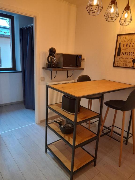 a dining room with a table and a microwave at Gîte En Li Esse in Huy