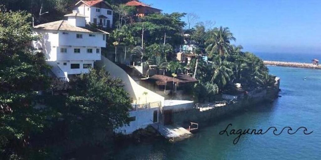 a large white house on an island in the water at Laguna Hostel in Rio de Janeiro