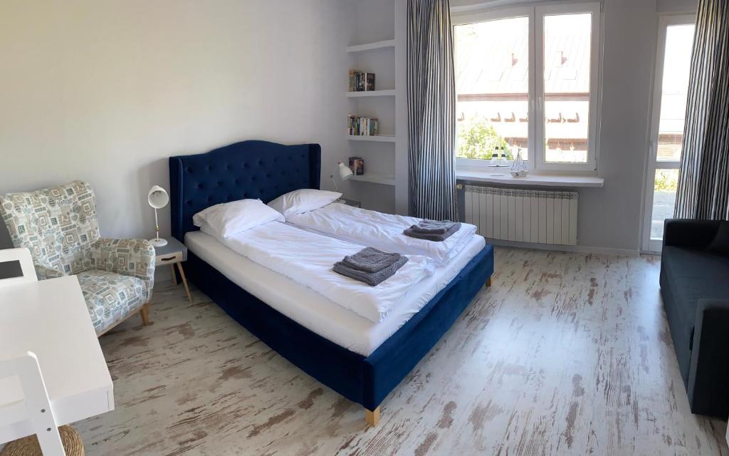 1 dormitorio con 1 cama azul y 1 sofá en Apartament nad jeziorem Białym, en Augustów