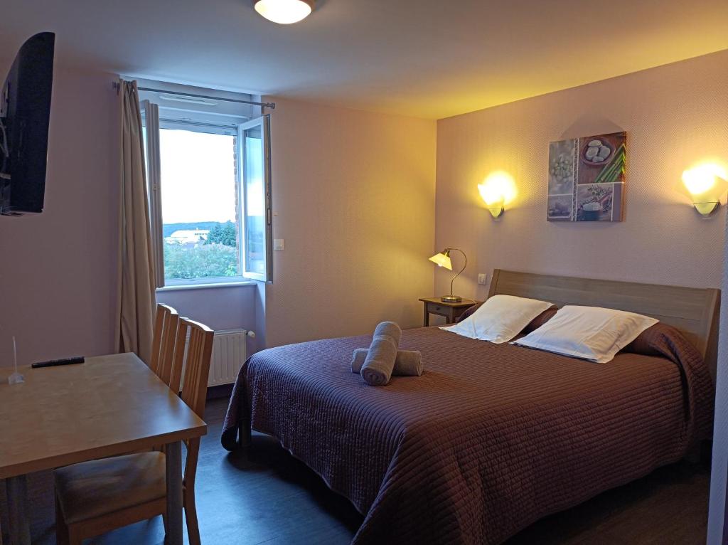 sypialnia z łóżkiem, stołem i oknem w obiekcie Les Pierres Folles w mieście Rozier-en-Donzy