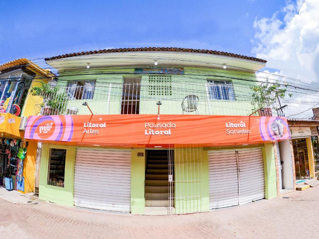 a building with an orange sign on the front of it at Pousada Litoral in Porto De Galinhas