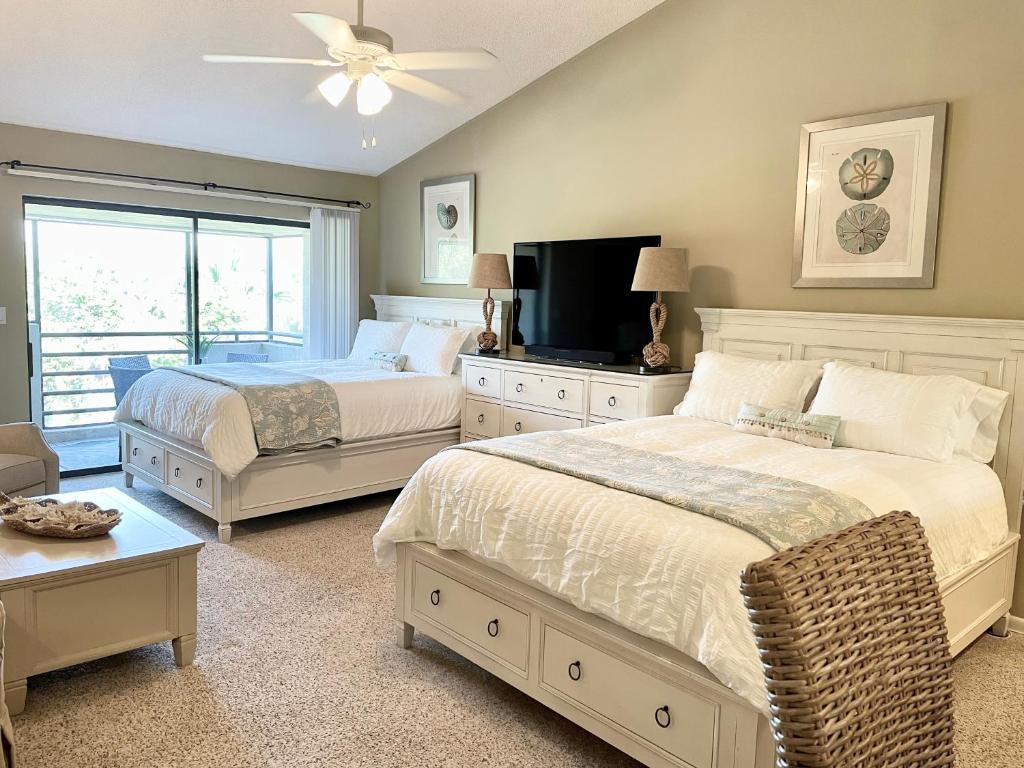 a bedroom with two beds and a flat screen tv at Gated Sawgrass Beach Club Villa in Sawgrass Country Club in Ponte Vedra Beach