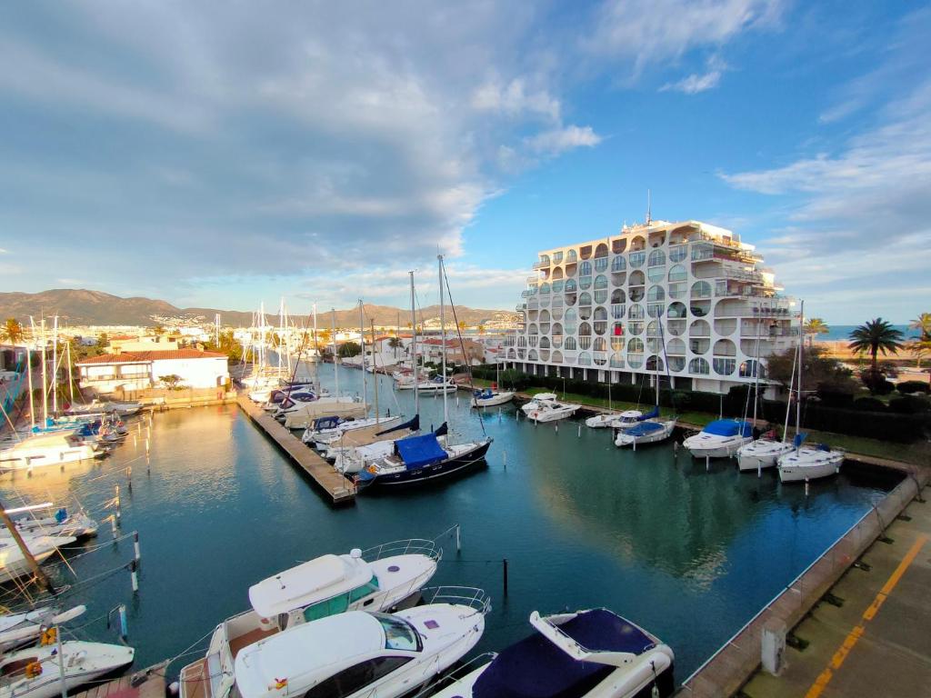 a marina with boats in the water and a building at Apartamento Bahia III in Empuriabrava
