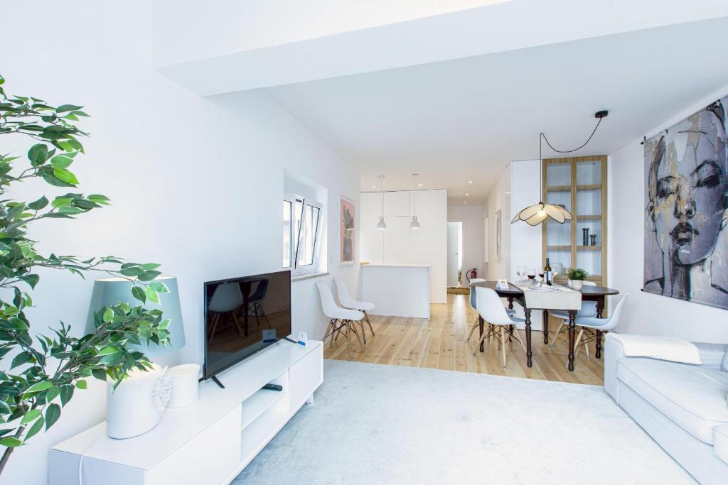 a living room with white furniture and a dining room at Modern & Charming Alges by GT House in Oeiras