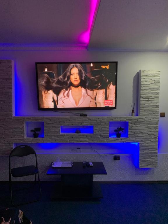 a living room with a tv on a brick wall at Karra Hotels in Voluntari