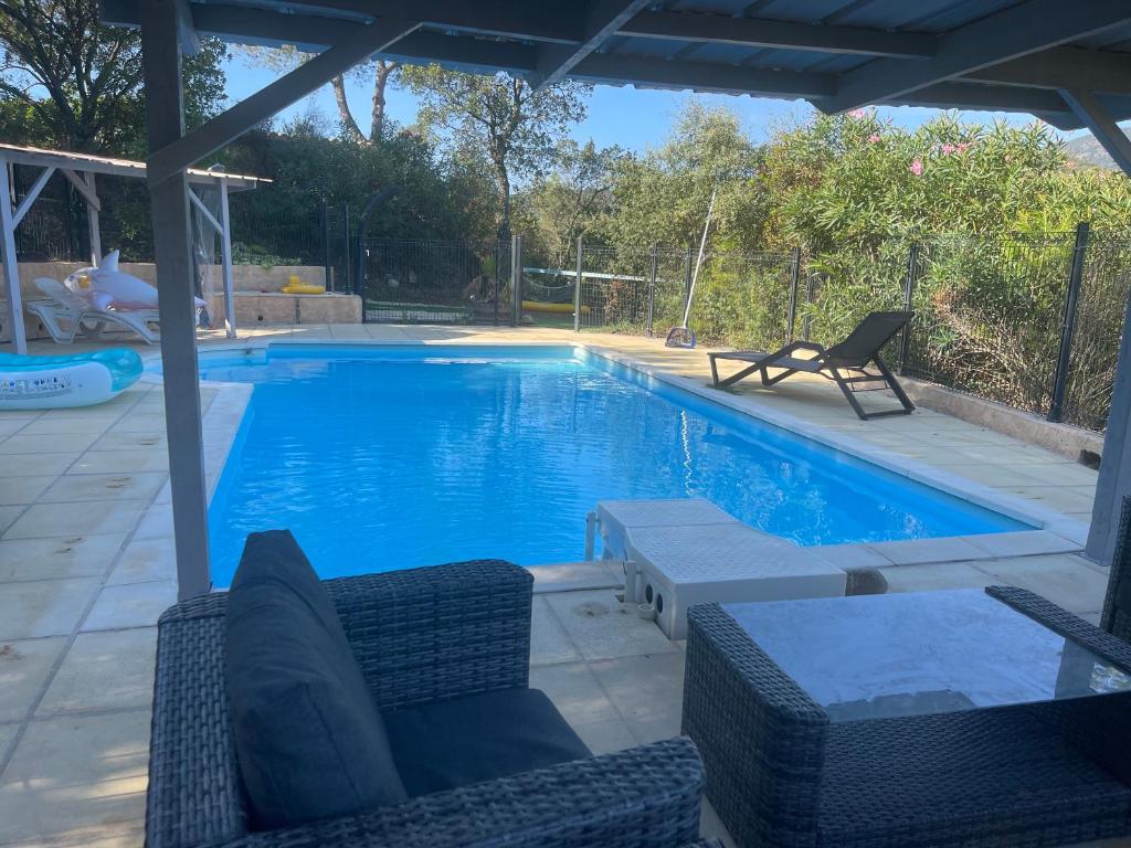 a large swimming pool with chairs and a table at Les Arches - Pardigon in La Croix-Valmer
