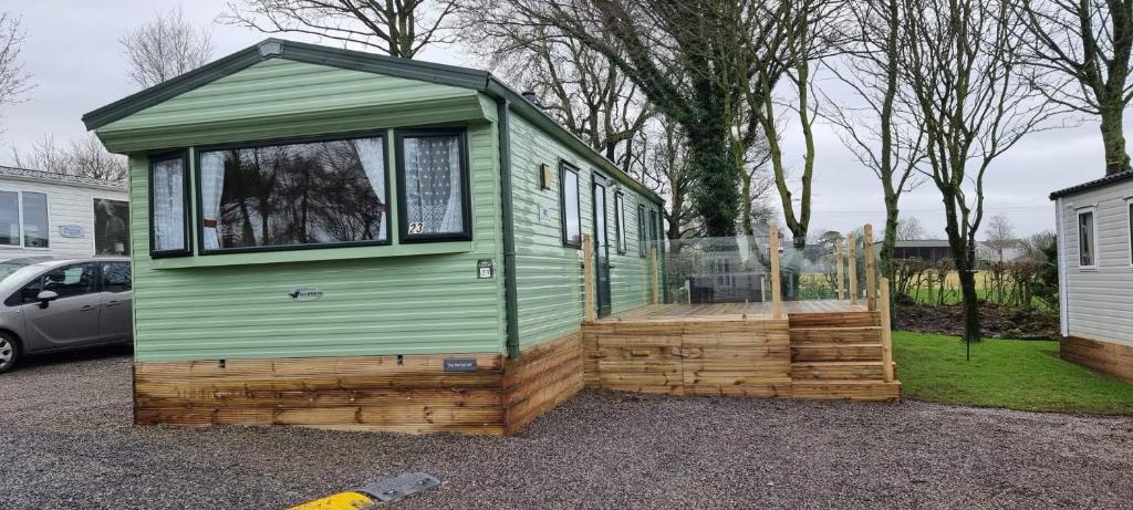 a green tiny house sitting in a parking lot at The Perrycroft at The Beeches Caravan Park in Gilcrux