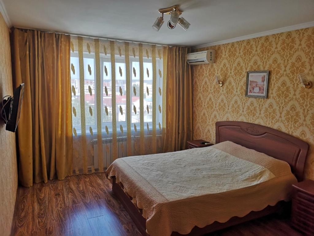 a bedroom with a bed and a large window at Central Park Apartment on Pushkin 33 in Chişinău