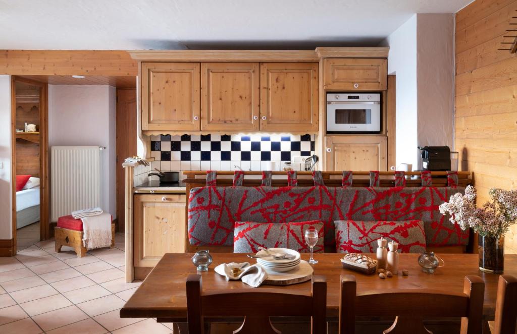 a kitchen with a wooden table and a dining room at Résidence Pierre &amp; Vacances Premium Les Alpages de Chantel in Arc 1800