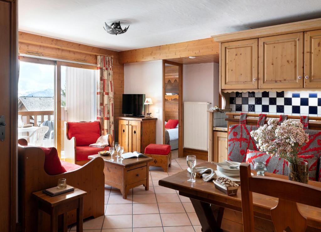 a kitchen and living room with a table and chairs at Résidence Pierre &amp; Vacances Premium Les Alpages de Chantel in Arc 1800