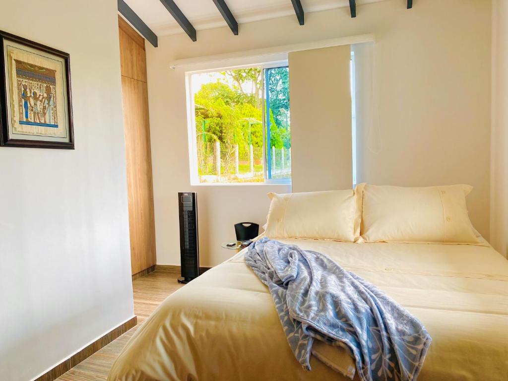 um quarto com uma cama e uma janela em Ruitoque Apartamento Campestre Maravillosa Vista em Floridablanca