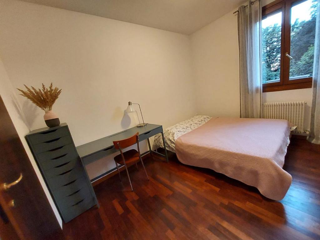 Schlafzimmer mit einem Bett, einem Schreibtisch und einem Fenster in der Unterkunft Private Room near Treviso "Mira" in Silea