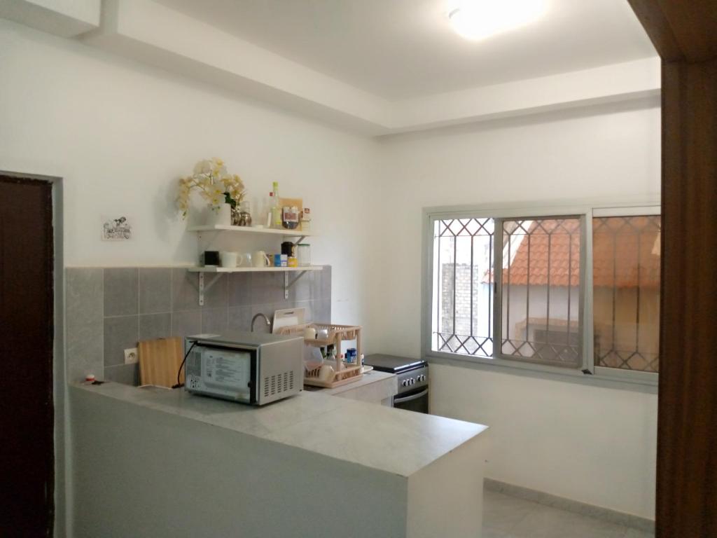 una cocina con encimera y microondas. en Appartement meublé en Dakar