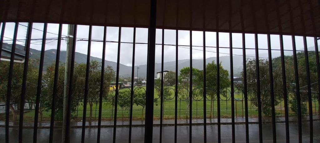 a window with a view of a mountain through a fence at Dota es Dota in Santa María