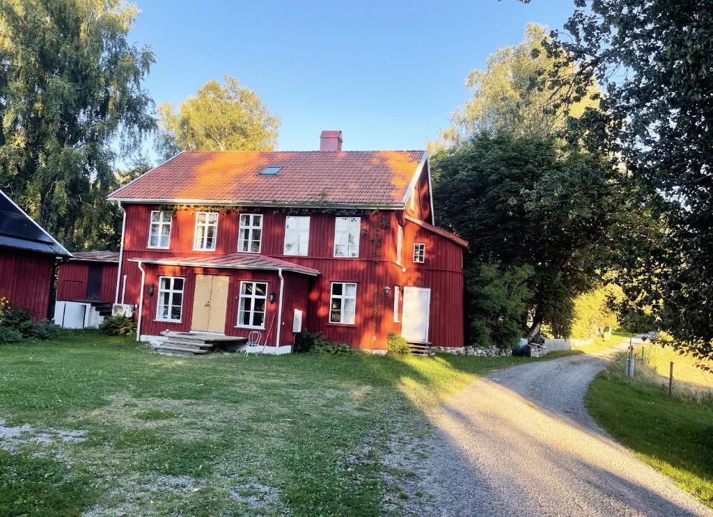 une ancienne maison rouge sur un chemin de terre dans l'établissement Idyllic holiday house in Sundshult, à Bullaren