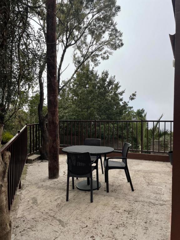 einen Tisch und zwei Stühle neben einem Zaun in der Unterkunft Casa Camino Los Chorros in Vallehermoso