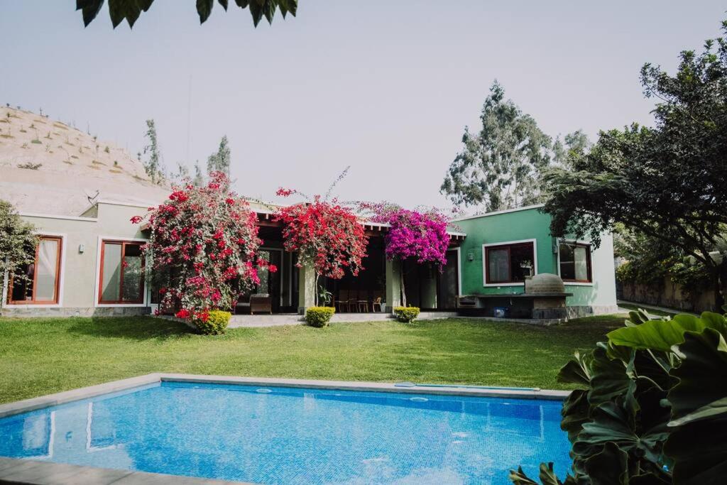 uma casa com piscina em frente a um quintal em Casa de Campo en Cieneguilla em Lima