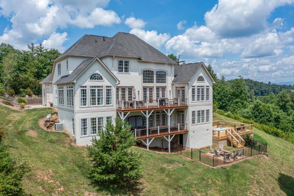 - une vue aérienne sur une grande maison blanche dotée d'une terrasse dans l'établissement Weekend friends and fam! Media room, Hot Tub, Firepit, Sleeps 18 minutes to Asheville, à Weaverville