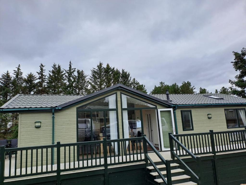 a tiny house with a porch and a glass door at Labernum Lodge - Springhouse Country Park in Slaley