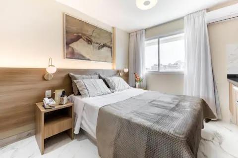 a bedroom with a large bed and a window at Suite Verano Stay in Rio de Janeiro