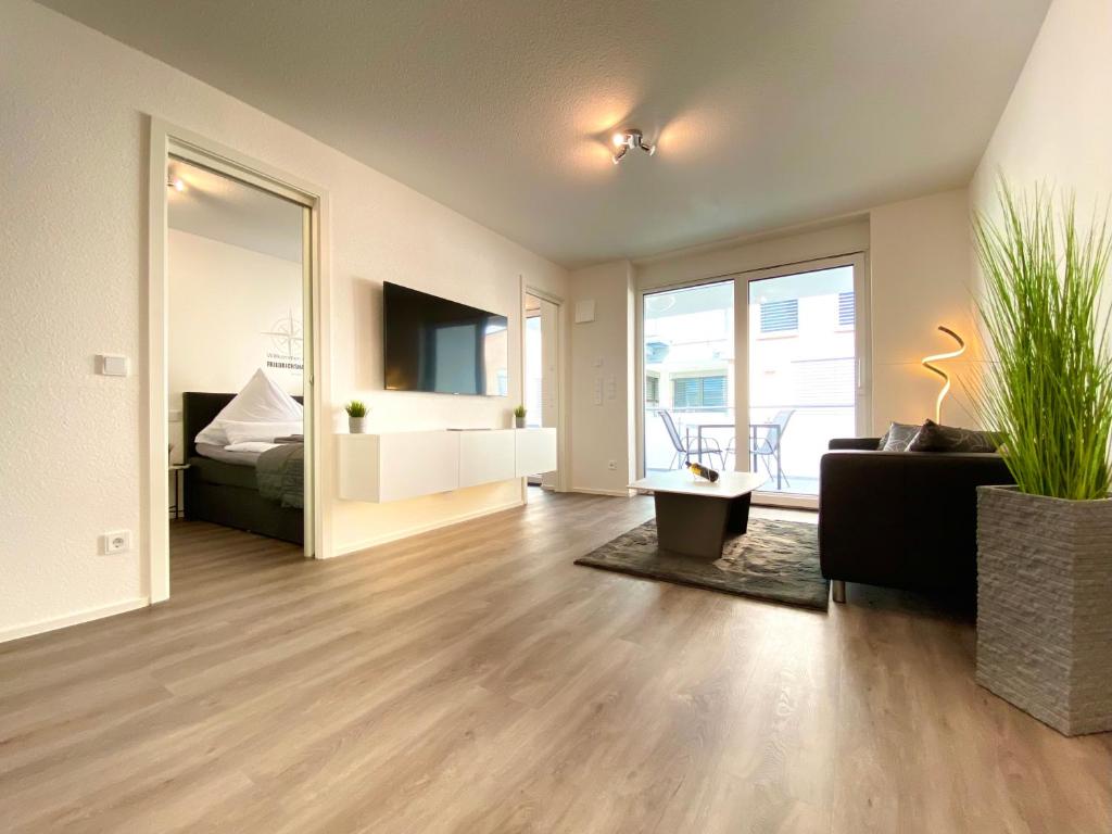 a living room with a couch and a bed and a mirror at Auszeit Apartment STYLE in Friedrichshafen