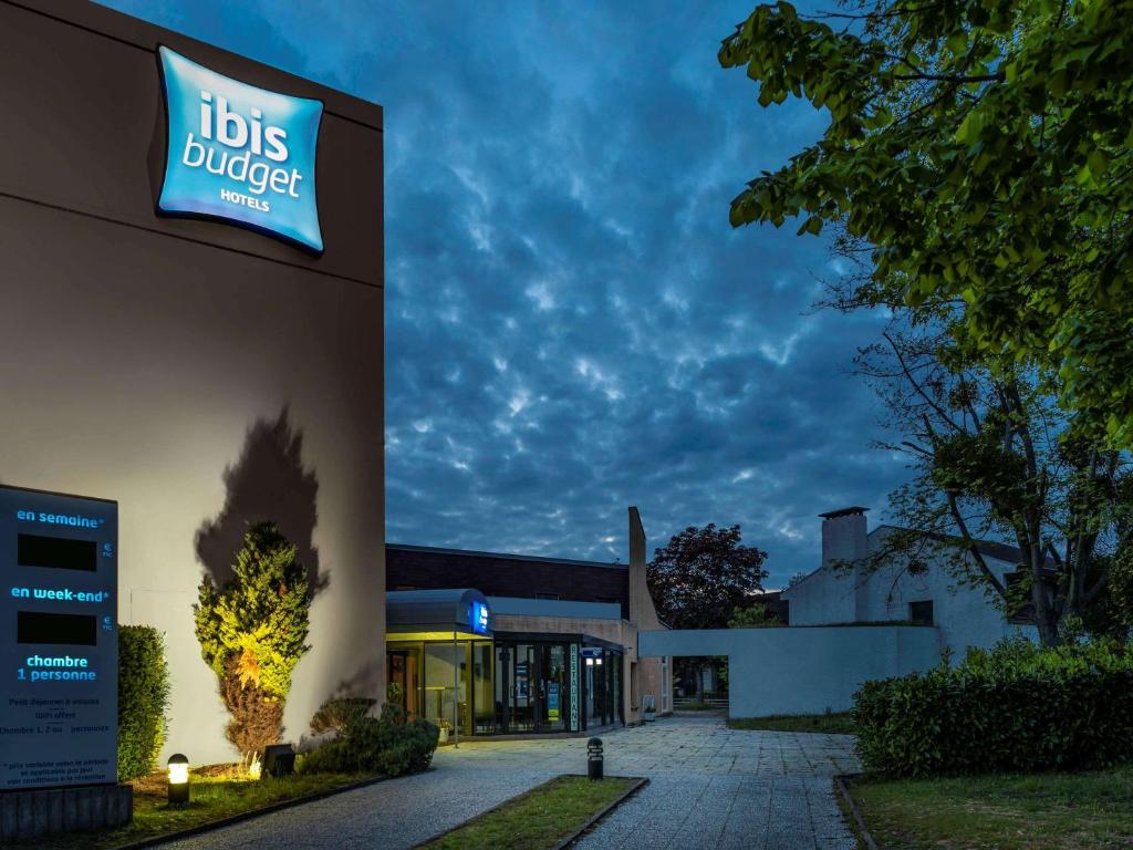 a building with a sign on the side of it at ibis budget Saint-Ouen-l'Aumône in Saint-Ouen-lʼAumône