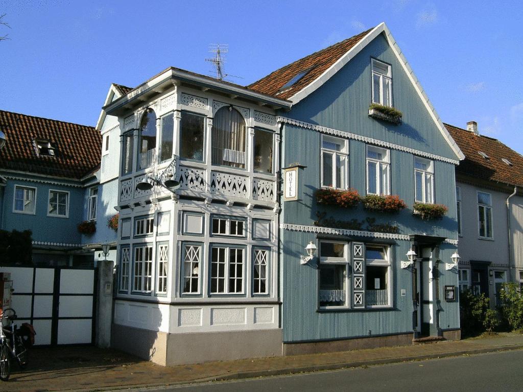 una casa azul y blanca al lado de una calle en Leisewitz' Garten, en Celle