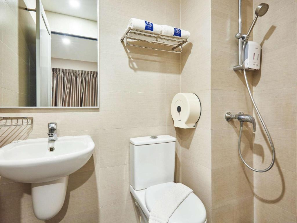 a bathroom with a toilet and a sink and a shower at ibis budget Singapore Clarke Quay in Singapore