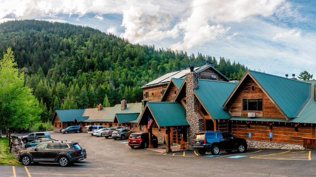 a building with cars parked in a parking lot in front of a mountain at Callahan's Lodge in Ashland