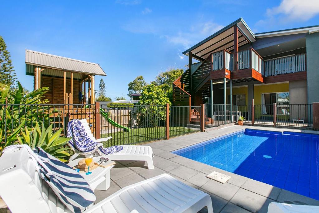 a home with a swimming pool and a house at Ivy Street 7 Dicky Beach in Caloundra