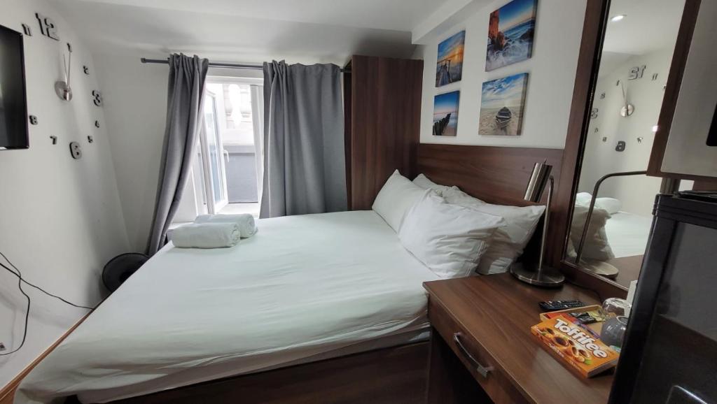 a bedroom with a white bed with a window at 72 Tottenham Court Road in London