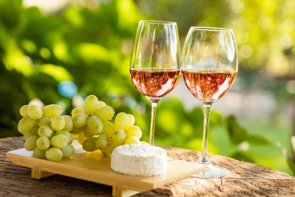 Palmilla的住宿－Hotel Viña Kankura，木桌旁放两杯葡萄酒和葡萄