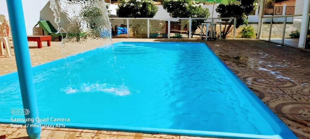 a blue swimming pool with a water fountain at Hotel 3 irmaos in Três Marias