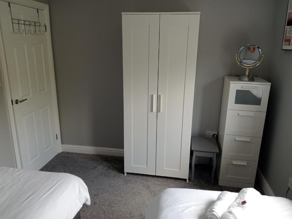 a bedroom with a white cabinet next to a bed at Green Street Retreat in York