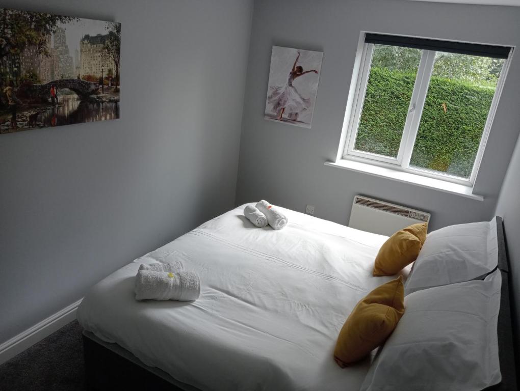 a white bed in a room with a window at Green Street Retreat in York