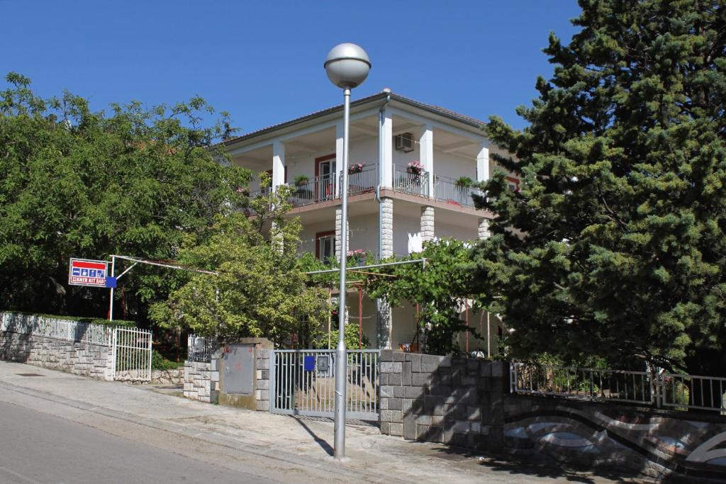 a white house with a porch and a street light at Apartment Selce 2379a in Selce