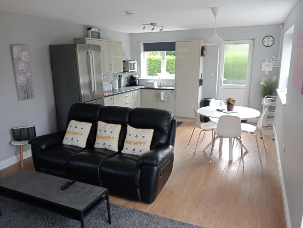 a living room with a black leather couch and a table at Green Street Retreat in York