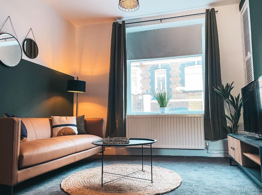 a living room with a couch and a window at Coronation House by Solace Stays in Merthyr Tydfil